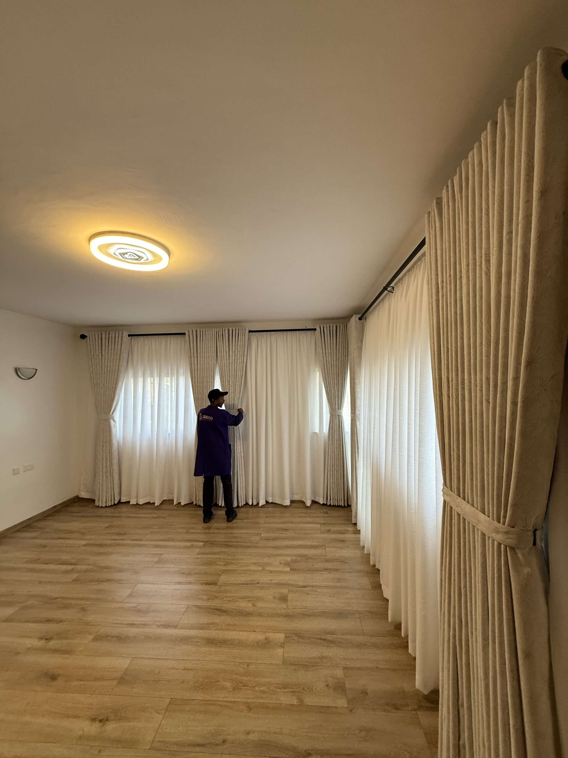 window curtain sheers receiving final installation touches at residence in kenya east africa by deco dreams curtains install technician fundi