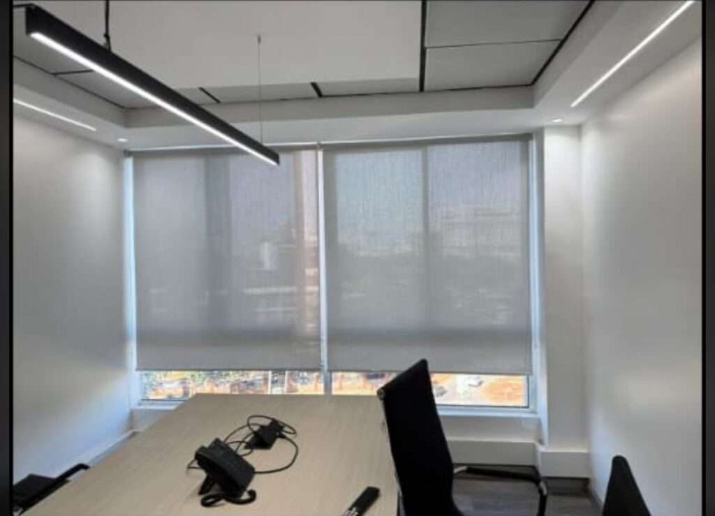 Installed roller blinds providing privacy and soft light in a modern office setup in Nairobi, Kenya.