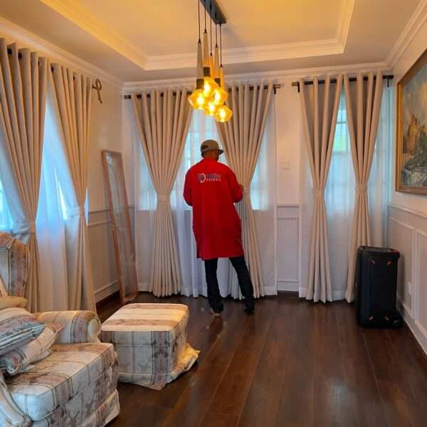 Curtain installer smoothing and aligning pleats after full installation.