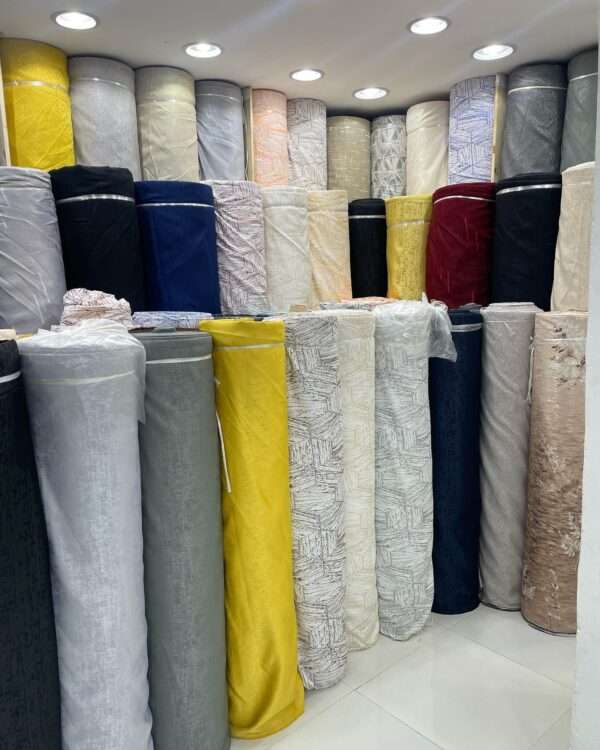 Colorful curtain fabric rolls stacked in Deco Dreams Curtains shop.