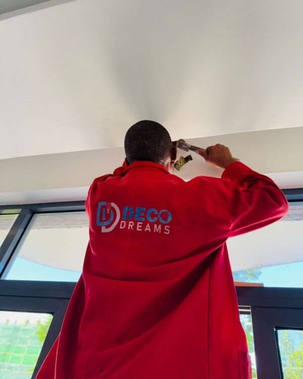 Installer drilling holes in wall for curtain rod installation.