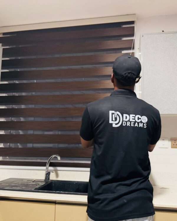 Finished blinds installation with technician reviewing final result.