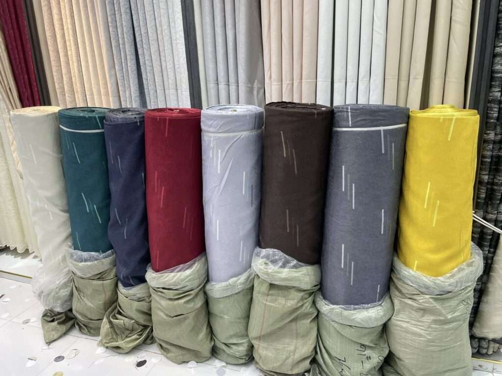 Colorful curtain fabric rolls stacked in Deco Dreams Curtains shop.